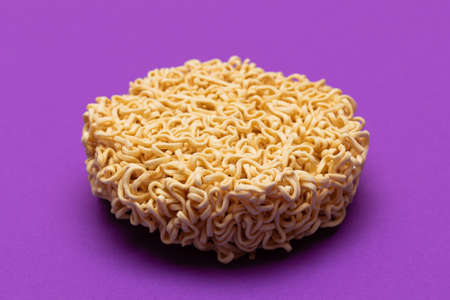 Uncooked Instant Noodles on Violet Background. Raw Pasta. Dry Asian Fast Food. Quick Lunchの写真素材