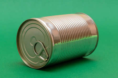 Unopened Tin Can with Blank Edge on Green Background. Canned Food. Aluminum Can for Safe and Long Term Storage of Food. Steel Sealed Food Storage Containerの写真素材
