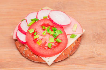 Crispy Cracker Sandwich with Tomato, Sausage, Cheese, Green Onions and Radish on Cutting Board. Easy Breakfast. Quick and Healthy Sandwiches. Crispbread with Tasty Filling. Healthy Dietary Snackの写真素材