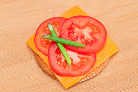 Crispy Cracker Sandwich with Tomato, Cheese and Green Onions on Cutting Board. Easy Breakfast. Diet Food. Quick and Healthy Sandwiches. Crispbread with Tasty Filling. Healthy Dietary Snackの写真素材