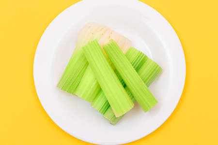 Fresh Chopped Celery Sticks on White Dish. Vegan and Vegetarian Culture. Raw Food. Healthy Diet with Negative Calorie Contentの写真素材