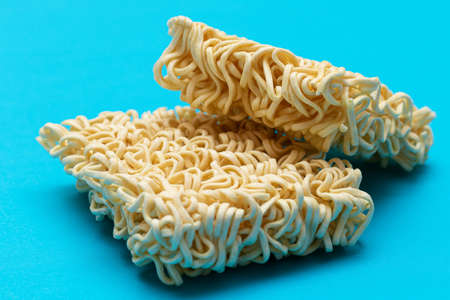 Uncooked Instant Noodles on Blue Background. Raw Pasta. Dry Asian Fast Food. Quick Lunchの写真素材