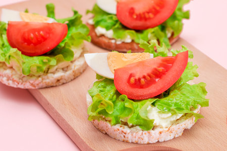 Rice Cake Sandwiches with Tomato, Lettuce and Egg on Wooden Cutting Board. Easy Breakfast. Diet Food. Quick and Healthy Sandwiches. Crispbread with Tasty Filling. Healthy Dietary Snackの写真素材