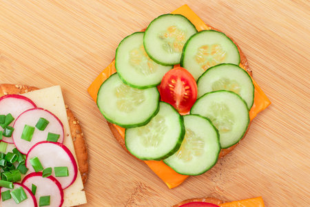 Different Cracker Sandwiches with Tomato, Cucumber, Radish and Cheese on Cutting Board. Easy Breakfast. Diet Food. Quick and Healthy Sandwiches. Crispbread with Tasty Filling. Healthy Dietary Snackの写真素材
