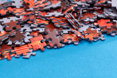 Mixed Peaces of a Colorful Jigsaw Puzzle Lie on the Blue Background - Strategy and Solving Problem Conceptの写真素材