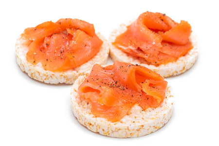 Tasty Rice Cake Sandwiches with Fresh Salmon Slices Isolated on White. Easy Breakfast and Diet Food. Crispbread with Red Fish. Healthy Dietary Snacks - Isolationの写真素材