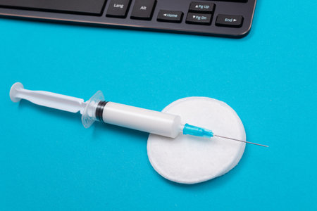 Vaccination, Immunology or Revaccination Concept - A Medical Syringe Lying on Blue Table in Doctors Office in a Hospital or Clinicの写真素材