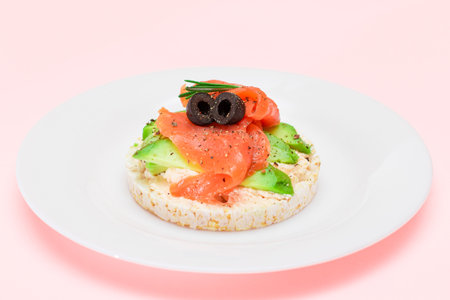 Rice Cake Sandwich with Fresh Salmon, Avocado and Olives on White Plate. Easy Breakfast. Diet Food. Quick and Healthy Sandwiches. Crispbread with Tasty Filling. Healthy Dietary Snackの写真素材