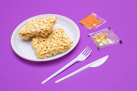 Uncooked Instant Noodles on White Plate. Raw Pasta. Dry Asian Fast Food. Quick Lunchの写真素材