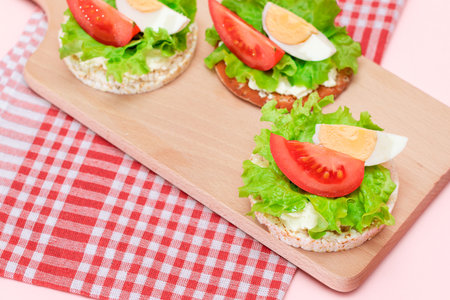 Rice Cake Sandwiches with Tomato, Lettuce and Egg on Wooden Cutting Board. Easy Breakfast. Diet Food. Quick and Healthy Sandwiches. Crispbread with Tasty Filling. Healthy Dietary Snackの写真素材