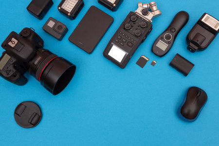 Top View of Photographers, Videographers or Video Bloggers Workplace. Digital Gadgets Lying on Blue Table - Flat Layの写真素材