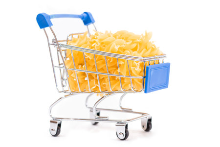 Uncooked Fusilli Pasta in Small Shopping Cart Isolated on White Background. A Crisis: Buying Cheap Food. Classic Dry Spiral Macaroni. Italian Culture and Cuisine. Raw Pasta - Isolationの写真素材
