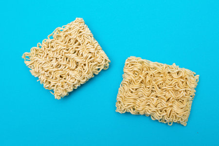Uncooked Instant Noodles on Blue Background. Raw Pasta. Dry Asian Fast Food. Quick Lunchの写真素材