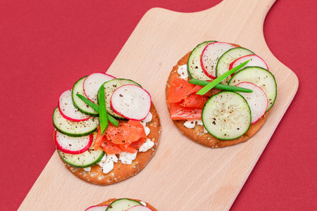Crispy Cracker Sandwiches with Fresh Salmon, Cucumber, Radish, Cottage Cheese and Green Onions. Easy Breakfast. Quick and Healthy Sandwiches. Crispbread with Tasty Filling. Healthy Dietary Snackの写真素材