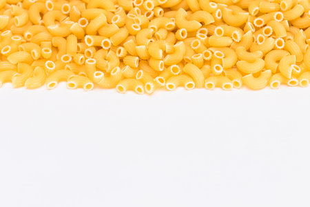 Uncooked Chifferi Rigati Pasta Scattered on White Table. Fat and Unhealthy Food. Classic Dry Macaroni. Italian Culture and Cuisine. Raw Pastaの写真素材