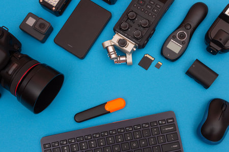 Top View of Photographers, Videographers or Video Bloggers Workplace. Digital Gadgets Lying on Blue Table - Flat Layの写真素材