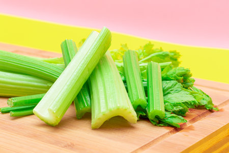 Fresh Celery Stem and Chopped Celery Sticks on Wooden Cutting Board. Vegan and Vegetarian Culture. Raw Food. Healthy Diet with Negative Calorie Content. Slimming Foodの写真素材