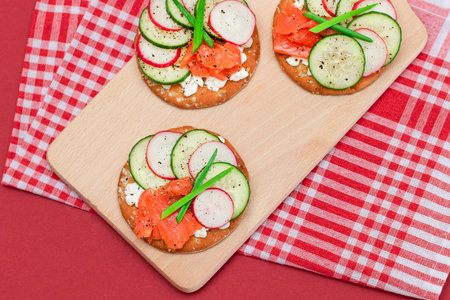 Crispy Cracker Sandwiches with Fresh Salmon, Cucumber, Radish, Cottage Cheese and Green Onions. Easy Breakfast. Quick and Healthy Sandwiches. Crispbread with Tasty Filling. Healthy Dietary Snackの写真素材