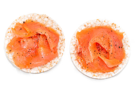Tasty Rice Cake Sandwiches with Fresh Salmon Slices Isolated on White - Top View. Easy Breakfast and Diet Food. Crispbread with Red Fish. Healthy Dietary Snacks - Isolationの写真素材