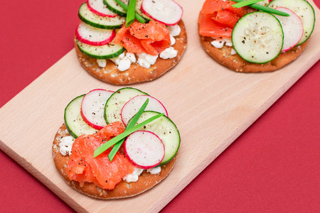 Crispy Cracker Sandwiches with Fresh Salmon, Cucumber, Radish, Cottage Cheese and Green Onions. Easy Breakfast. Quick and Healthy Sandwiches. Crispbread with Tasty Filling. Healthy Dietary Snackの写真素材