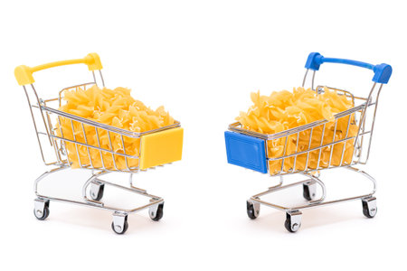 Uncooked Fusilli Pasta in Two Small Shopping Carts Isolated on White Background. A Crisis: Buying Cheap Food. Classic Dry Spiral Macaroni. Italian Culture and Cuisine. Raw Pasta - Isolationの写真素材