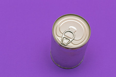 Unopened Tin Can with Blank Edge on Violet Background. Canned Food. Aluminum Can for Safe and Long Term Storage of Food. Steel Sealed Food Storage Containerの写真素材