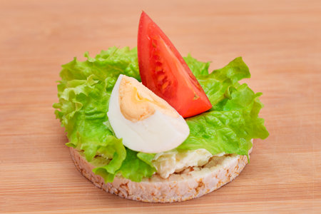 Rice Cake Sandwich with Tomato, Lettuce and Egg on Bamboo Cutting Board. Easy Breakfast. Diet Food. Quick and Healthy Sandwiches. Crispbread with Tasty Filling. Healthy Dietary Snackの写真素材