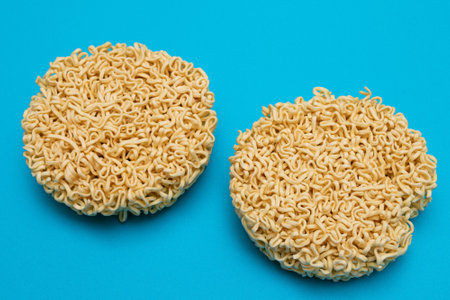 Uncooked Instant Noodles on Blue Background. Raw Pasta. Dry Asian Fast Food. Quick Lunchの写真素材