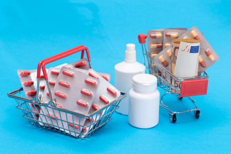 Buying Medicines. Drug Addiction Concept: Pills and Capsules in Shopping Cart on Blue Background. Global Pharmaceutical Industry and Big Pharma. Ordering Pharmaceutical Productsの写真素材