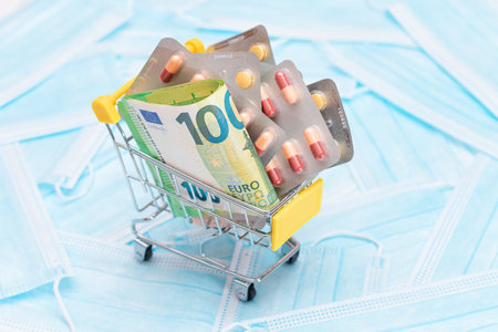 Buying Medicines. Expensive Medicine and Inflation Concept: Pills and Capsules in Shopping Cart on the Surgical Masks. Global Pharmaceutical Industry and Big Pharma. Ordering Pharmaceutical Productsの写真素材