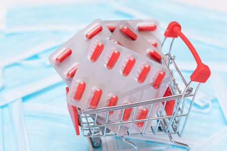 Buying Medicines. Expensive Medicine and Inflation Concept: Pills and Capsules in Shopping Cart on the Surgical Masks. Global Pharmaceutical Industry and Big Pharma. Ordering Pharmaceutical Productsの写真素材