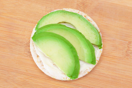 Rice Cake Sandwich with Fresh Avocado and Cream Cheese on Bamboo Cutting Board. Easy Breakfast. Diet Food. Quick and Healthy Sandwiches. Crispbread with Tasty Filling. Healthy Dietary Snackの写真素材