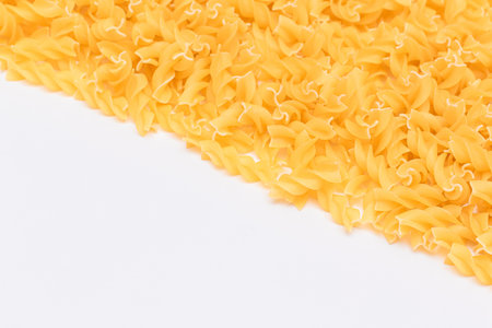 Uncooked Fusilli Pasta with Copy Space on White Background. Raw and Dry Macaroni. Fat and Unhealthy Food - Flat Layの写真素材