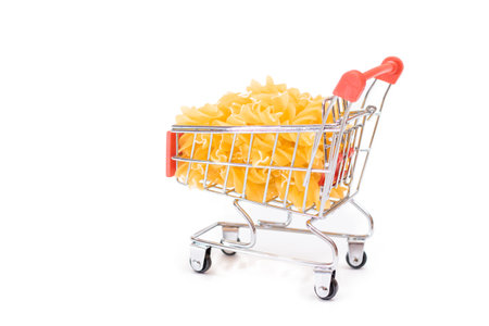 Uncooked Fusilli Pasta in Small Shopping Cart Isolated on White Background. A Crisis: Buying Cheap Food. Classic Dry Spiral Macaroni. Italian Culture and Cuisine. Raw Pasta - Isolationの写真素材