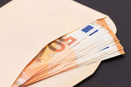 An Orange Paper Envelope with Stack of 50-Euro Banknotes Inside. Salary in Cash. Tax-Free System....