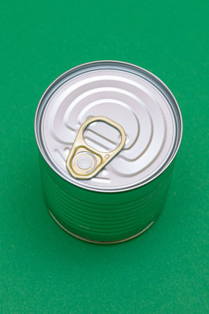 Unopened Tin Can with Blank Edge on Green Background. Canned Food. Aluminum Can for Safe and Long Term Storage of Food. Steel Sealed Food Storage Containerの写真素材