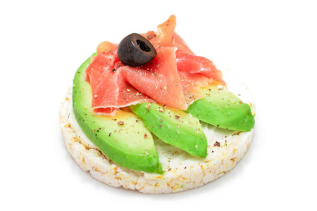 Rice Cake Sandwich with Fresh Avocado, Jamon and Olives - Isolated on White. Easy Breakfast. Diet Food. Quick and Healthy Sandwiches. Crispbread with Tasty Filling. Healthy Dietary Snack - Isolationの写真素材