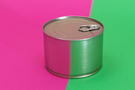 Tin Can on Split Green and Cyan Background. Canned Food. Aluminum Can for Safe and Long Term Storage...