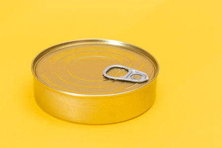 Tin Can on Yellow Background. Canned Food. Aluminum Can for Safe and Long Term Storage of Food....