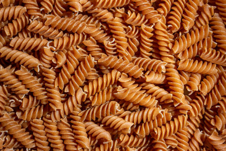 Uncooked Whole Grain Fusilli Pasta: A Culinary Canvas of Whole Wheat Spirals, Creating a Lively and...