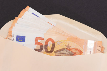 An Orange Paper Envelope with Stack of 50-Euro Banknotes Inside. Salary in Cash. Euro Currency....