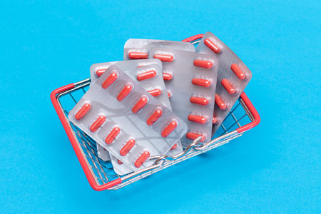 Buying Medicines. Drug Addiction Concept: Pills and Capsules in Shopping Basket on Blue Background....