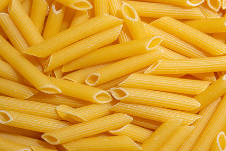 Uncooked Penne Rigate Pasta: A Culinary Canvas of Penne Macaroni, Creating a Lively and Textured Background for Gourmet Cooking. Dry Pasta. Raw Macaroni - Top View, Flat Layの写真素材