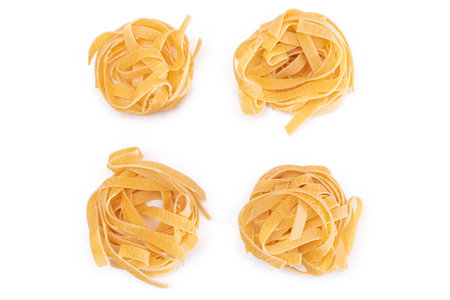 Four Classic Italian Raw Egg Fettuccine - Isolated on White Background. Dry Twisted Uncooked Pasta. Italian Culture and Cuisine. Raw Golden Macaroni Pattern - Isolationの写真素材