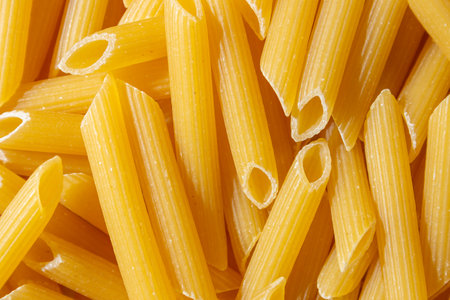 Uncooked Penne Rigate Pasta: A Culinary Canvas of Penne Macaroni, Creating a Lively and Textured Background for Gourmet Cooking. Dry Pasta. Raw Macaroni - Top View, Flat Layの写真素材