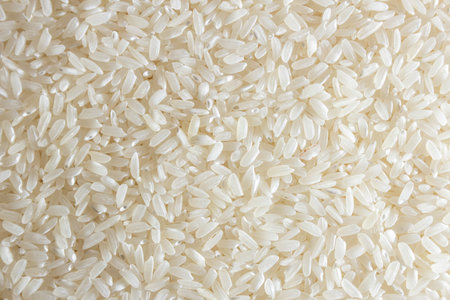 Dry Uncooked White Rice Background - Top View, Flat Lay. Scattered Raw Long Grain Rice. Asian Cuisine and Culture. Healthy Eating Ingredients. Diet Foodの写真素材