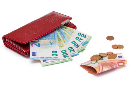 Red Leather Women Purse with Different Euro Banknotes and Euro Cent Coins - Isolated on White Background. A Wallet Full of European Union Paper Money Symbolizing Wealth and Success - Isolationの写真素材