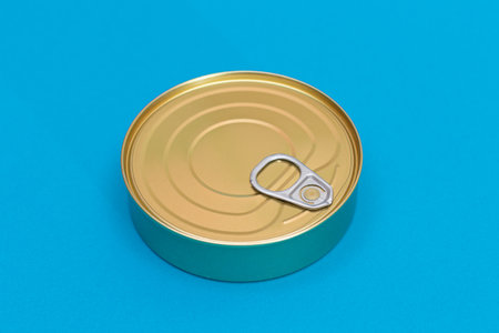 Tin Can on Blue Background. Canned Food. Aluminum Can for Safe and Long Term Storage of Food. Steel Sealed Food Storage Containerの写真素材
