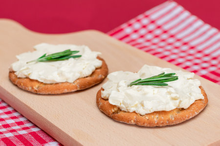 Crispy Cracker Sandwich with Cream Cheese and Rosemary on Wooden Cooking Boardの写真素材