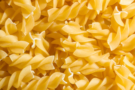 Uncooked Fusilli Pasta: A Culinary Canvas of Spiral Macaroni, Creating a Lively and Textured Background for Gourmet Cooking. Dry Pasta. Raw Macaroni - Top View, Flat Layの写真素材